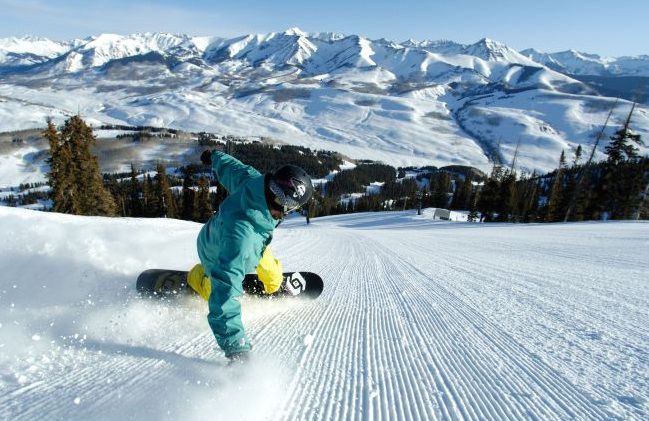 Snowoboarder grooming the runs at Crested Butte Mountain Resort.